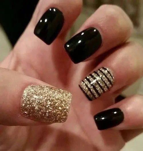 Photo of black and gold nails with black stripes as acccent
