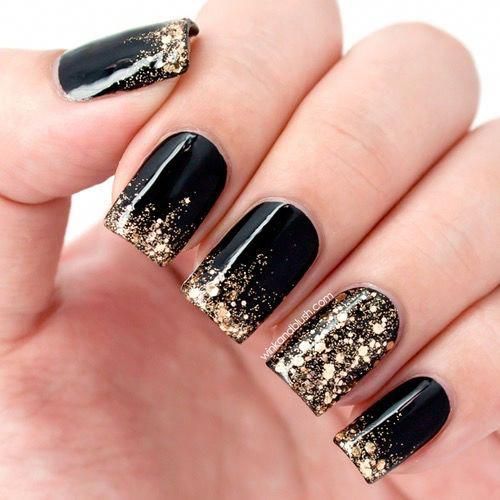 Photo of black nails with dipped gold glitter at tips