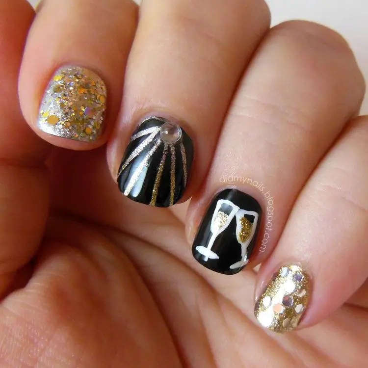 Photo of black and gold nails with glitter and champagne glasses